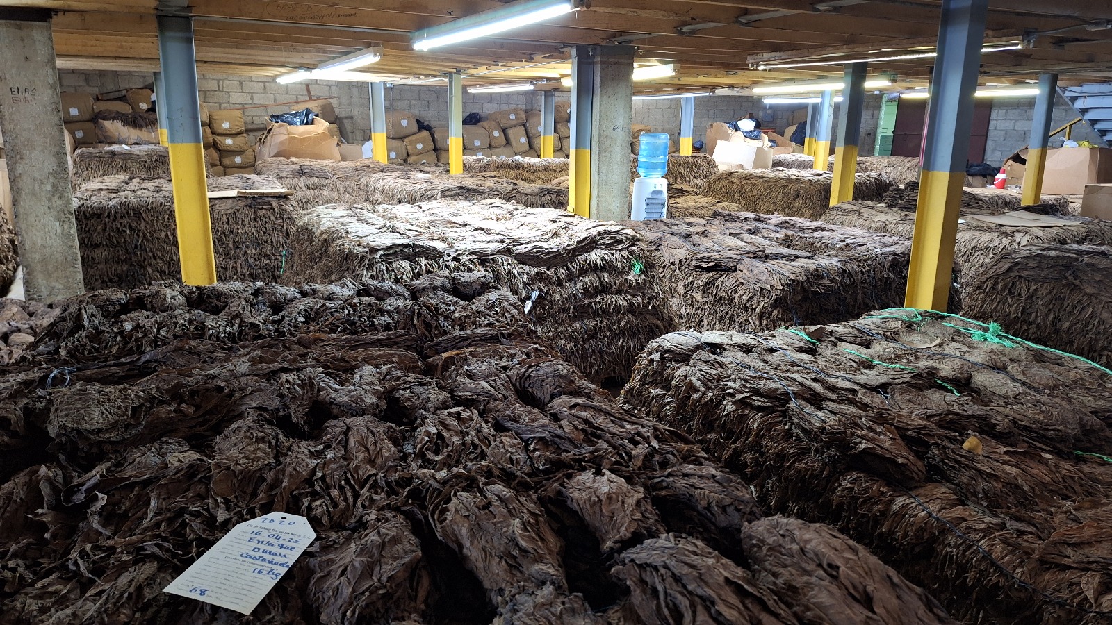 Aged tobacco bales stretching across the slow-fermentation hall.