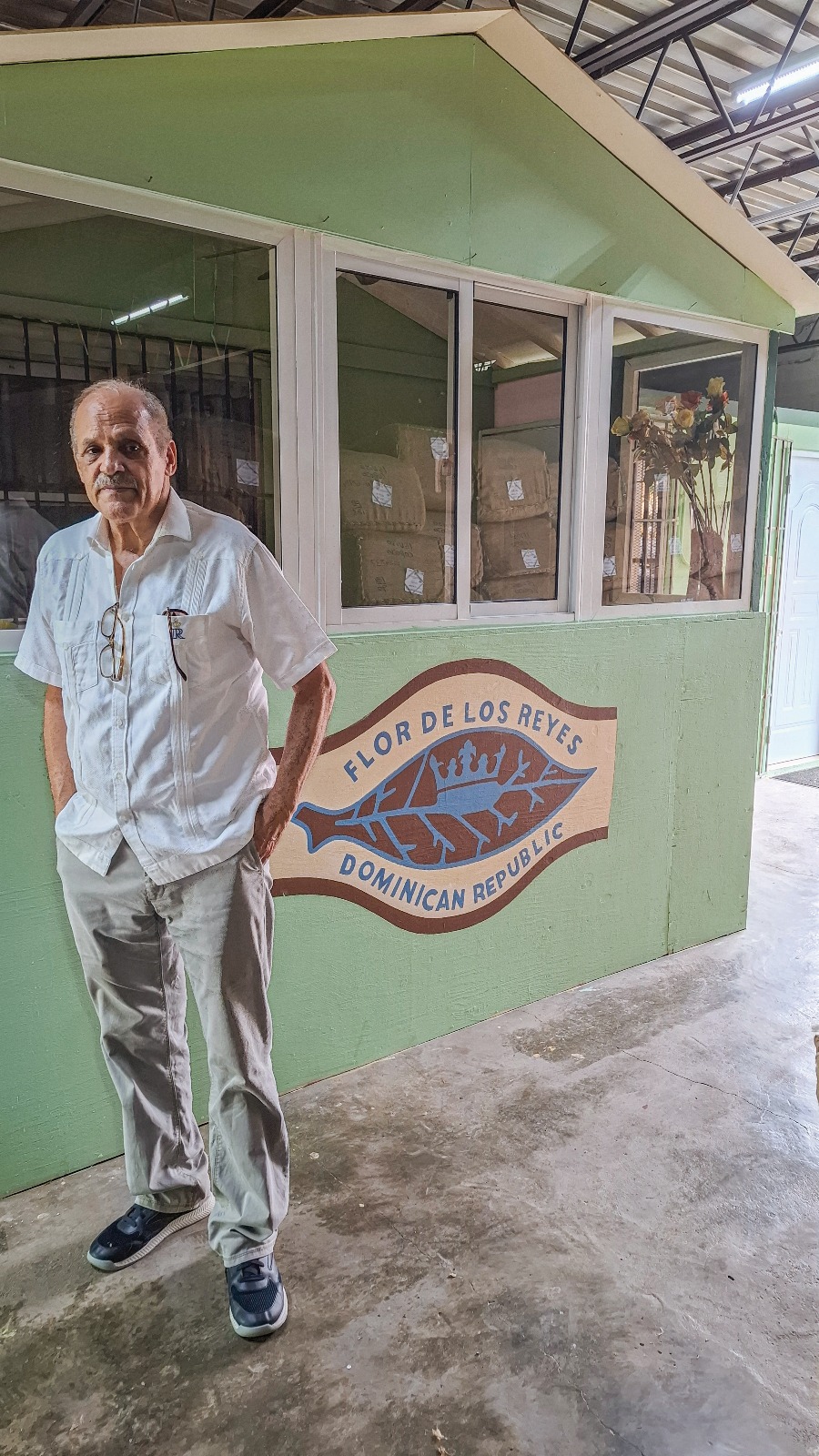 Tío Leo standing beside the Flor de los Reyes mural at the family workshop in Navarrete.